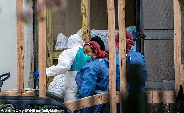 27056966-8209161-image-m-57_1586551422116 A number of bodies were loaded into a refrigerated morgue truck in Brooklyn on Friday