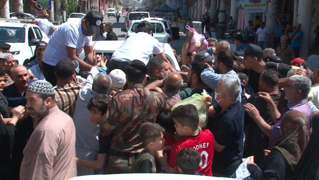 بالصور.. تدافع وزحام على سلال غذائية في بغداد تدافع وزحام عند توزيع سلال غذائية في بغداد (الجزيرة)