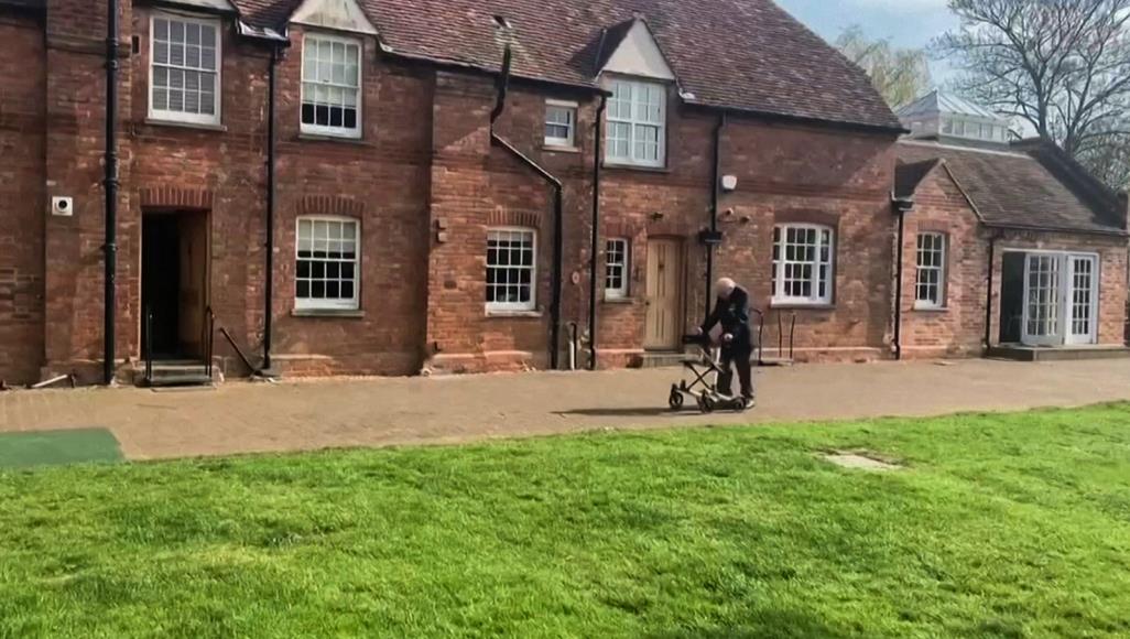 مور استكمل السير مئة مرة حول حديقته الخميس باستخدام مشاية لمساعدته (رويترز)