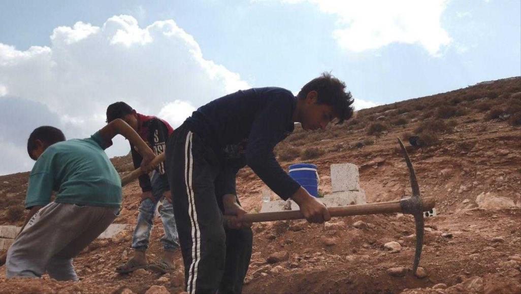 الجزيرة نت إلى نهائيات جائزة ويبي.. بعد تأهل تقرير "مهنة الموت لأجل البقاء" أحمد وشقيقه وطفل ثالث يحفرون قبرا لمتوفٍ جديد (الجزيرة نت-أرشيف)