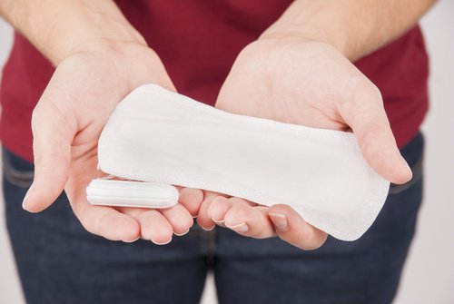 سيدة تمسك بفوطة صحية والتي تستخدم خلال الدورة الشهرية