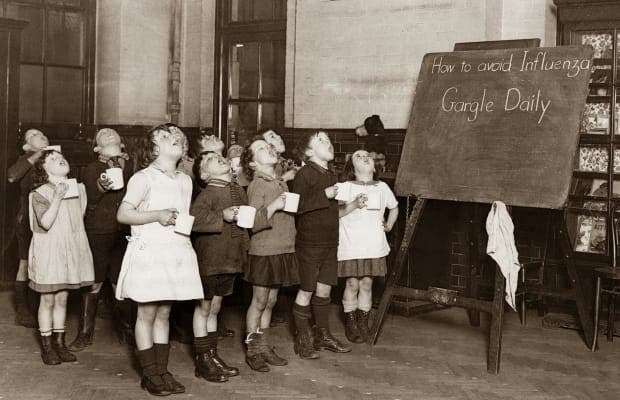 صورة لأطفال حصلوا على تعليمات طبية بممارسة الغرغرة بالماء باحدى المدارس زمن الأنفلونزا