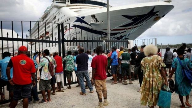 114082255_whatsubject عمال محليون ينتظرون سفينة سياحية في فانواتو في ديسمبر/كانون الأول 2019