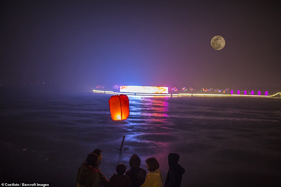 10036306-6724033-image-a-20_1550652840449 A family enjoys the view of the super bright moon over the river in Shandong Province, China. A supermoon occurs when the moon's orbit is closest (perigee) to the Earth at the same time it is full, according to NASA