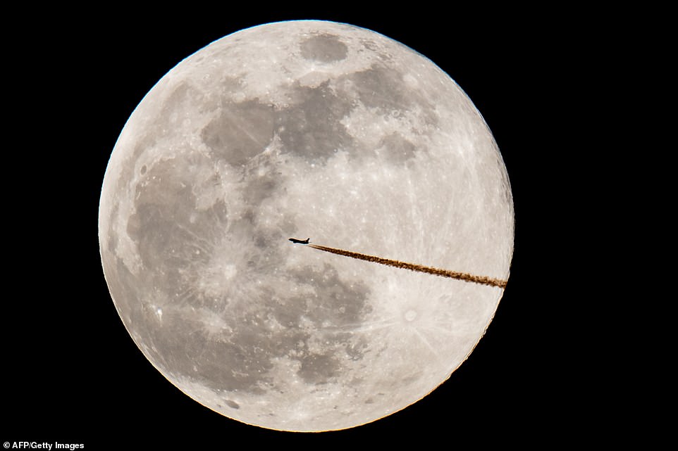 10038462-6724033-image-a-33_1550655432230 An airplane silhouettes against the moon in Nuremberg. The event is the second of three supermoon events in the first three months of the year, which marks the 50th anniversary of Apollo 11, the mission that took the first humans to the moon