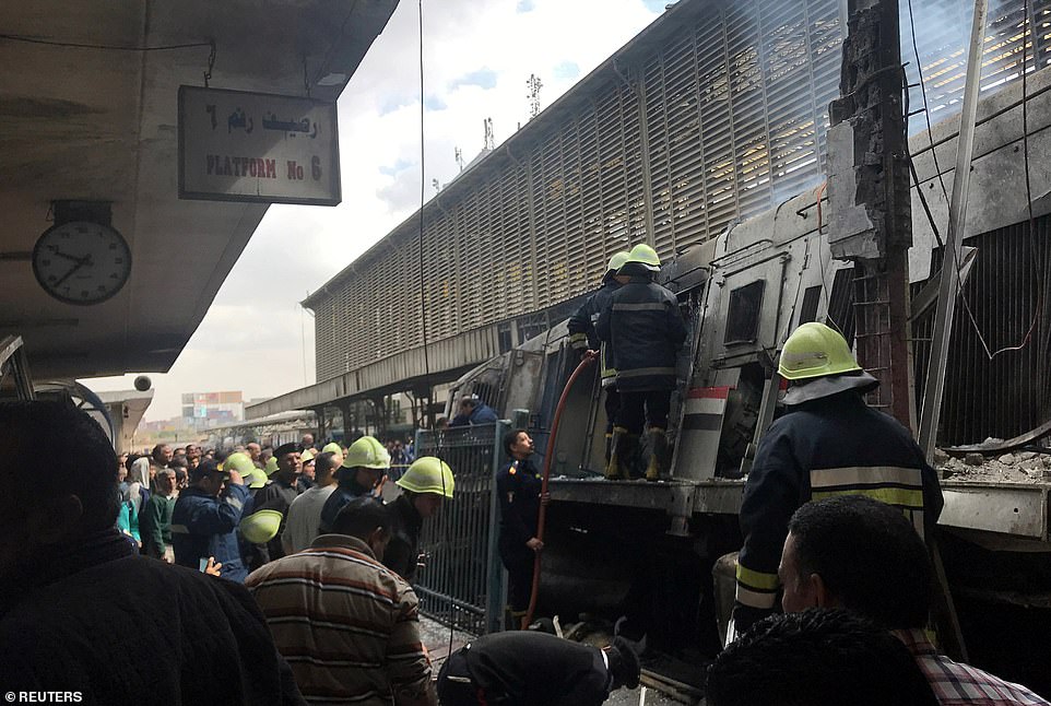 Fire crews clamber over the wreckage of the train after extinguishing the blaze