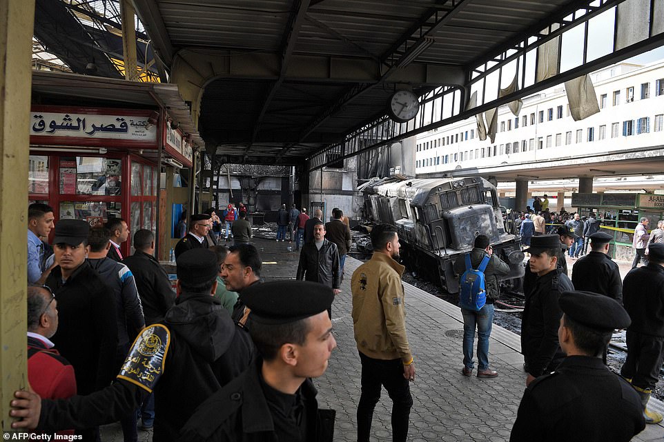 Members of the security forces and onlookers gather at the scene of the crash