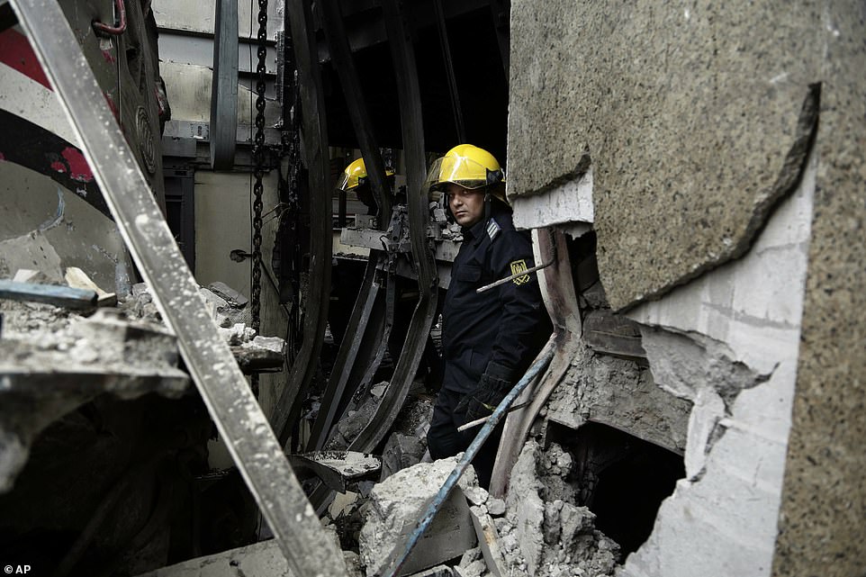 Firefighters work at the scene of a train crash inside Ramsis train station in Cairo, Egypt
