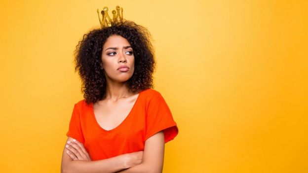 105604352_4a بورتريه لامرأة مختالة متغطرسة تضع تاجا على رأسها، عاقدة زراعيها، ومن ورائها خلفية صفراء