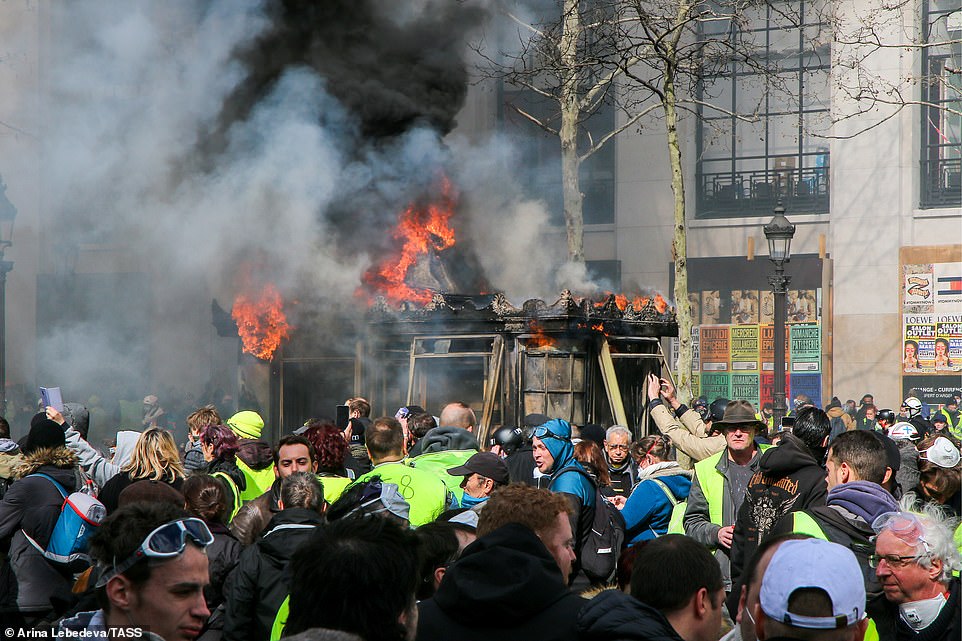11077782-6816815-image-a-71_1552752013367 A small structure is on fire in the centre of a busy pavement as yellow vest protests continue in Paris