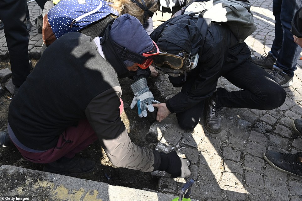 11077804-6816815-image-a-67_1552751991312 Yellow vests protesters break the rocks on sidewalks during the demonstrations