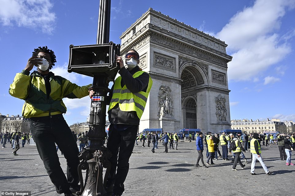 11077806-6816815-image-a-63_1552751976423 Yellow vests, or Gilets jaunes, protesters stage a demonstration on a lamppost on avenue Champs Elysees