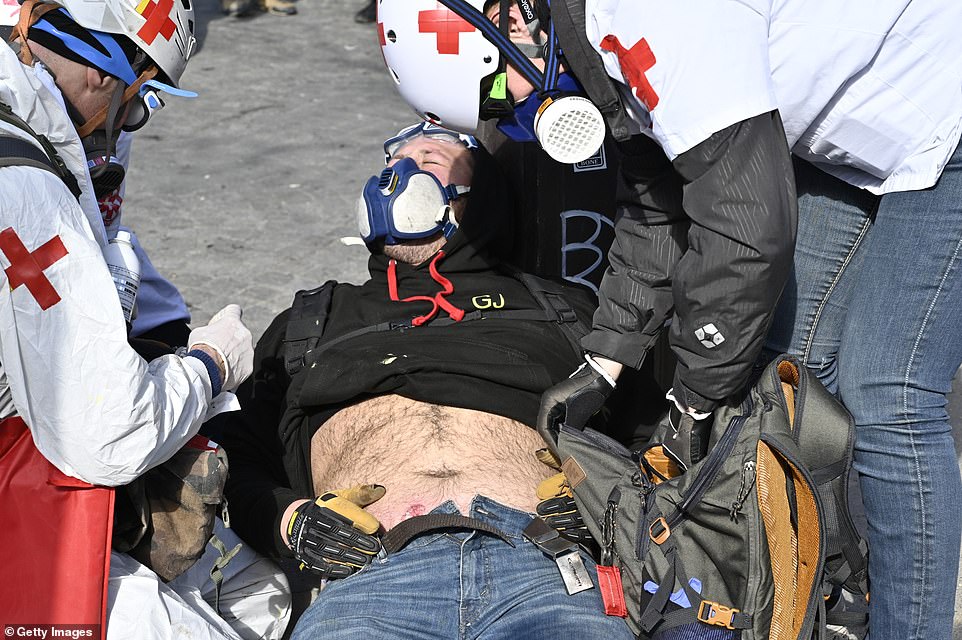 11077840-6816815-image-a-77_1552752065526 A yellow vests protester lies on the ground after getting injured by security forces during a demonstration on avenue Champs Elysees