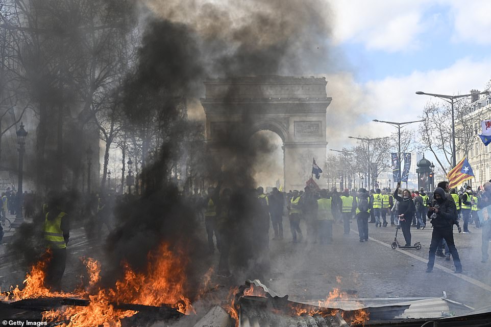 11077854-6816815-image-a-90_1552752204277 Yellow vests protesters setup a barricade using fire during by avenue Champs Elysees in Paris today