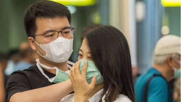 110797213_gettyimages-1197056161 مواطن يساعد زميلته على ارتداء القناع