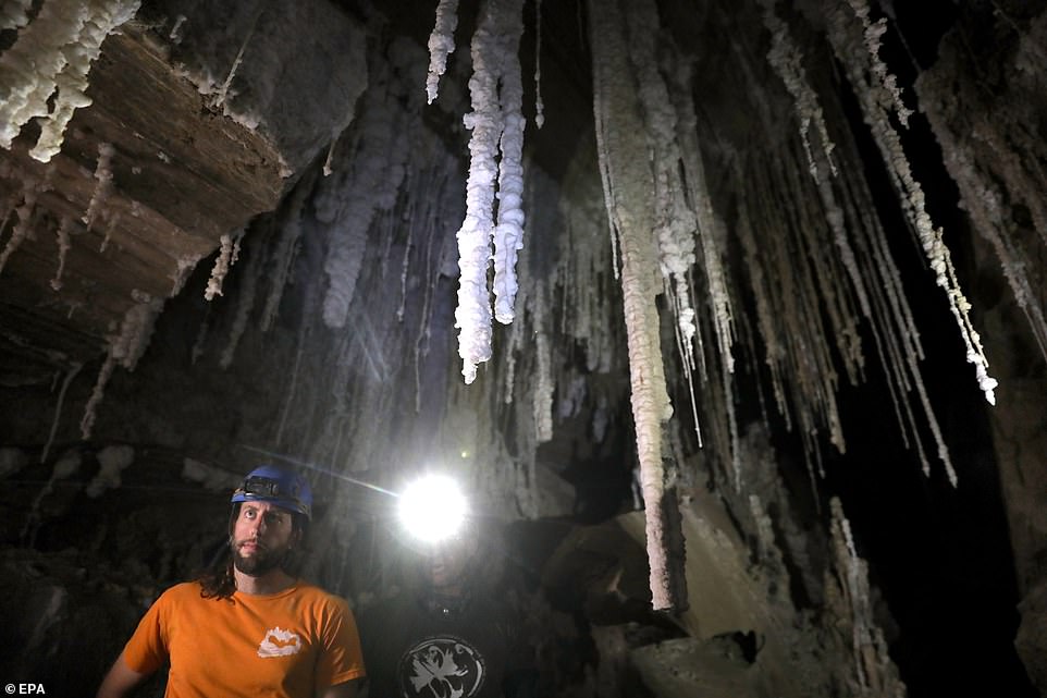 11569494-6858793-image-a-25_1553779527676 Much of the cave's interior is covered by a fine dust that blows in from the desert. Massive slabs of salt, some amber-coloured from dust and minerals, jut out in dramatic formations