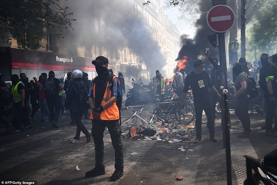 As of 1 pm, 110 people had been arrested and placed in custody, the Paris prosecutor's office said. A man stands in a ruined city street