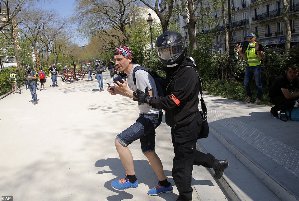 A police officer moves a man during today's protest.Â The city was on high alert after Christophe Castaner, the interior minister, said domestic intelligence services had informed him of a potential return of rioters