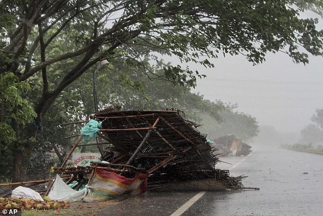 13038568-6988125-image-a-3_1556868256085 Collapsed: A street stand is toppled over in the winds as Indian authorities evacuate the homes of more than a million people amid the storm