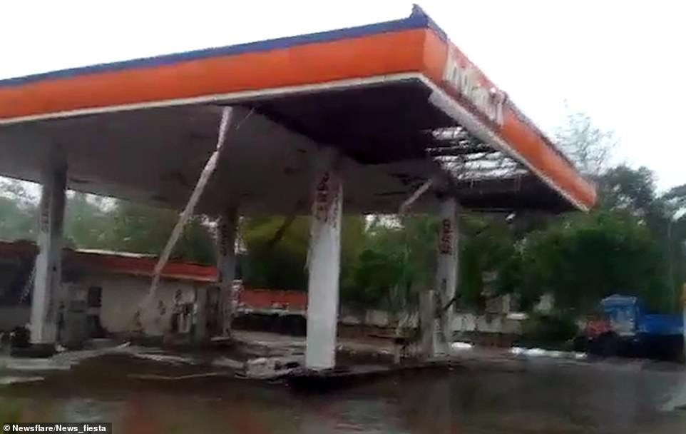 13054672-6988125-image-m-3_1556897600509 Ravaged: A petrol station is seen with debris on the ground after the 130mph cyclone struck India's east coast on Friday