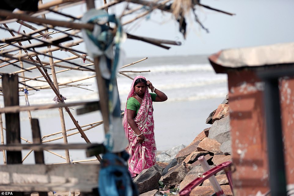 13077774-6991719-image-a-15_1556954542108 An Indian woman reconstructs a food shop after Cyclone Fani hit the town of Digha in West Midnapore district, West Bengal, India, today