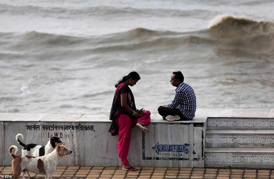 13077782-6991719-image-a-20_1556954558759 People sit on the shore after Cyclone Fani hit Digha in West Midnapore district, West Bengal, India, today
