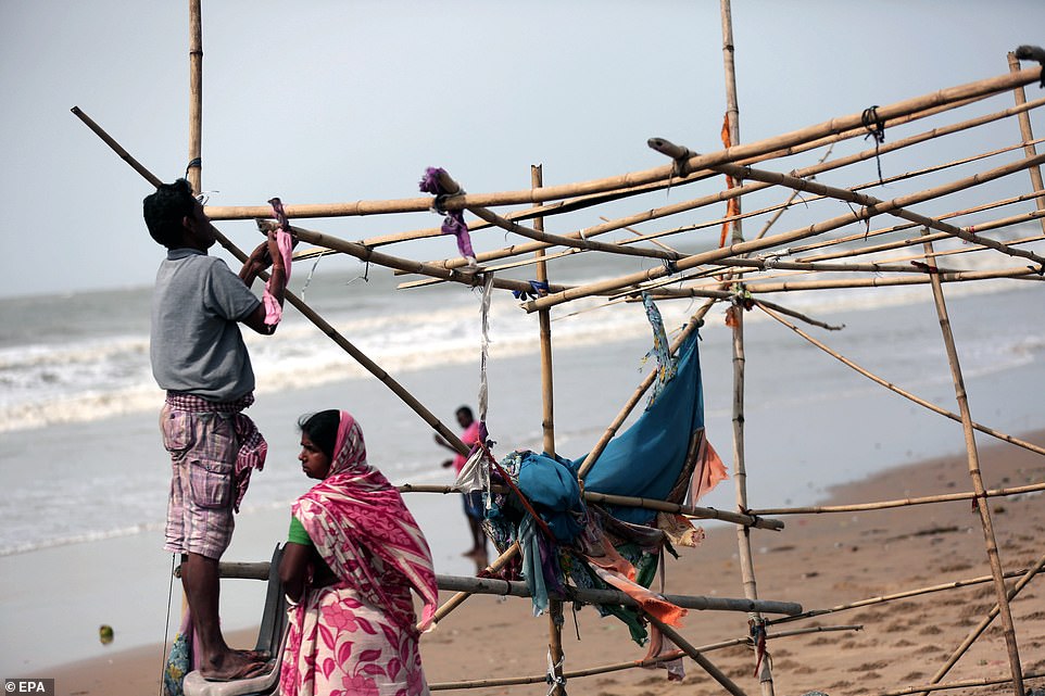 13077784-6991719-image-a-22_1556954570640 An Indian family reconstructs their food shop after Cyclone Fani hit the town of Digha in West Midnapore district, West Bengal, India, May 4