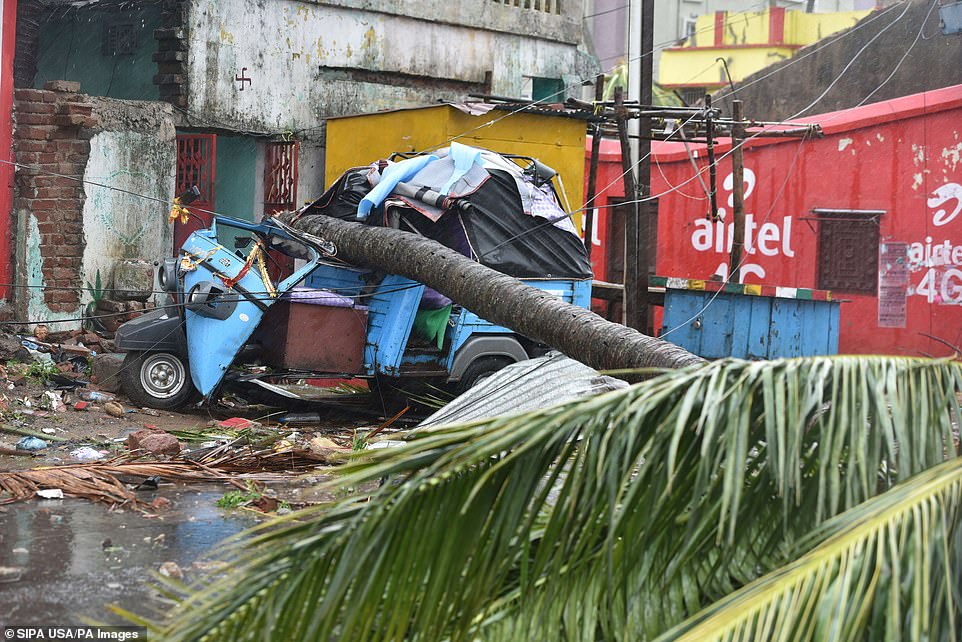 13077956-6991719-image-a-31_1556954689691 A fallen tree and damaged vehicle seen after the onset of cyclone Fani on May 3, 2019 in Puri, India
