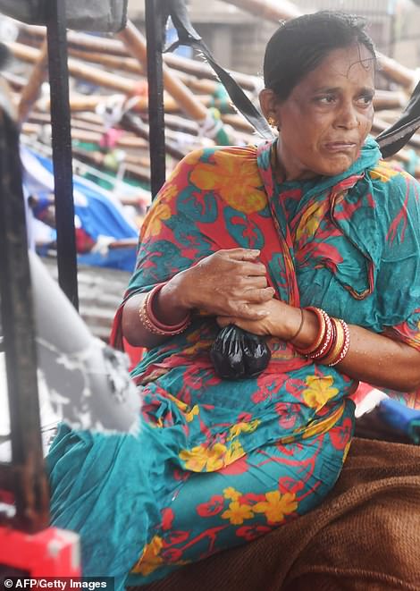 13077972-0-image-a-42_1556954713143 The woman is soaked through as she clutches her belongings