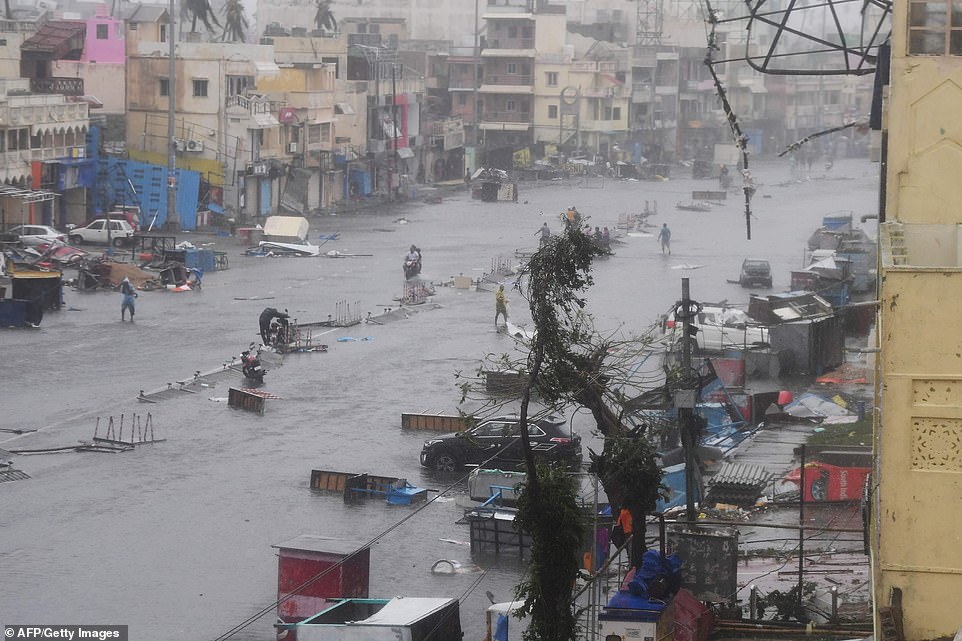 13077996-6991719-image-a-47_1556954750793 Indian residents ride along a road next to damaged trees oafter Cyclone Fani landfall in Puri in the eastern Indian state of Odisha on May 3