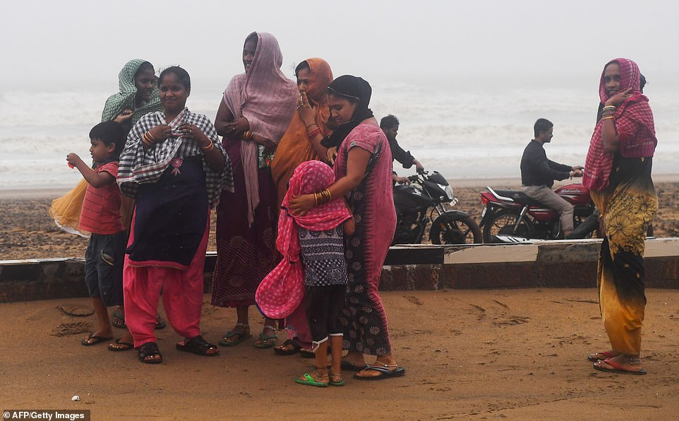 13078018-6991719-image-a-57_1556954845871 The families stand on a beachfront huddling together after Cyclone Fani landfall in Puri, in the eastern Indian state of Odisha on May 3, 2019