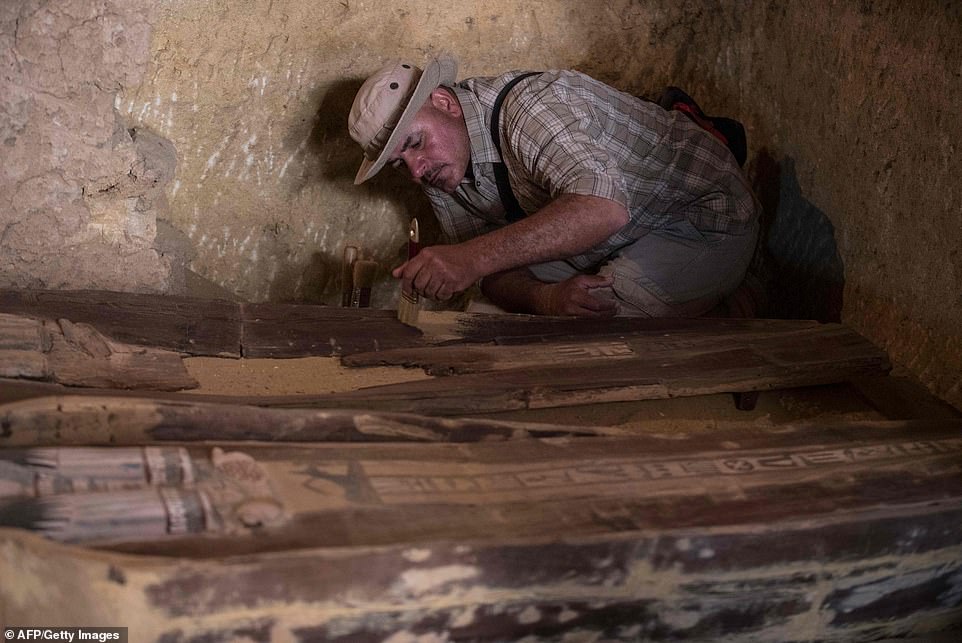 13086252-6992141-image-a-23_1556984505611 Another member of the excavation team carefully brushes away sand and debris from the sarcophagus