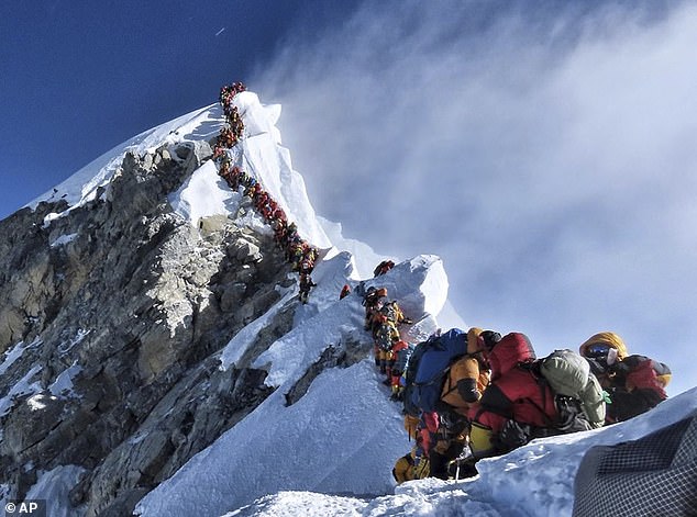 14402978-7107865-image-a-21_1559744301493-2 Along queue of mountain climbers line a path on Mount Everest. 11 climbers died on Everest this climbing season, most while descending from the congested summit during only a few windows of good weather each May