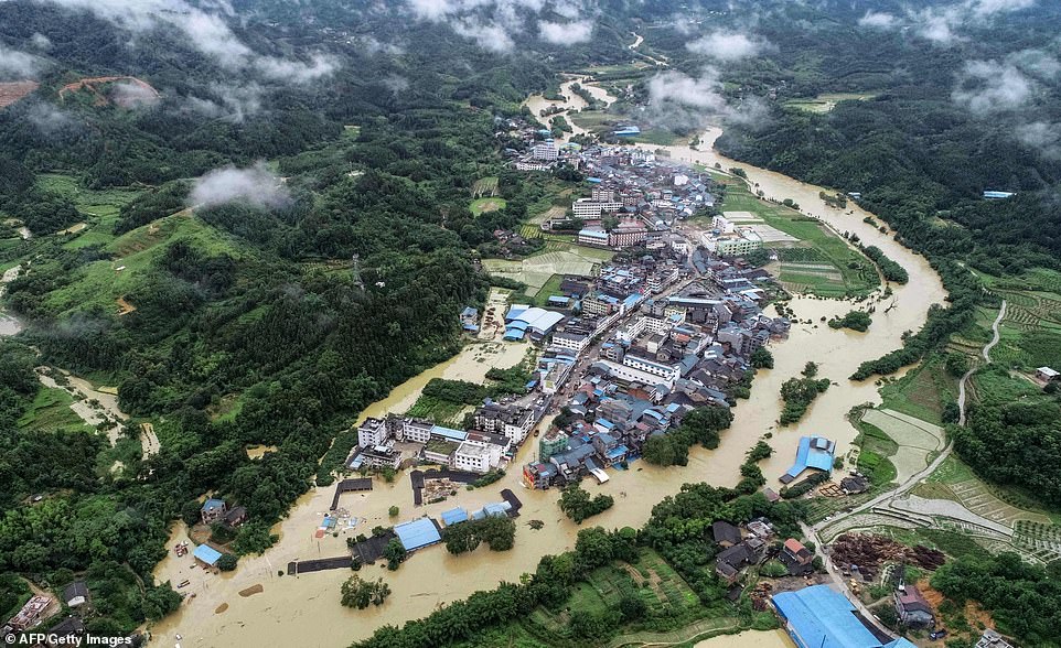 14689326-7132619-image-a-14_1560344995580 An aerial image shows buildings and other infrastructure submerged in floodwaters in Rongan, Guangxi region