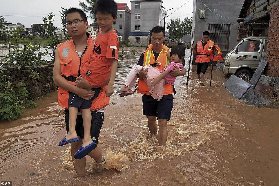 14689330-7132619-image-a-27_1560345383975 Rescuers transfer children as the floods hit Xiangxing Township of Yongxin county in Ji'an city, Jiangxi province