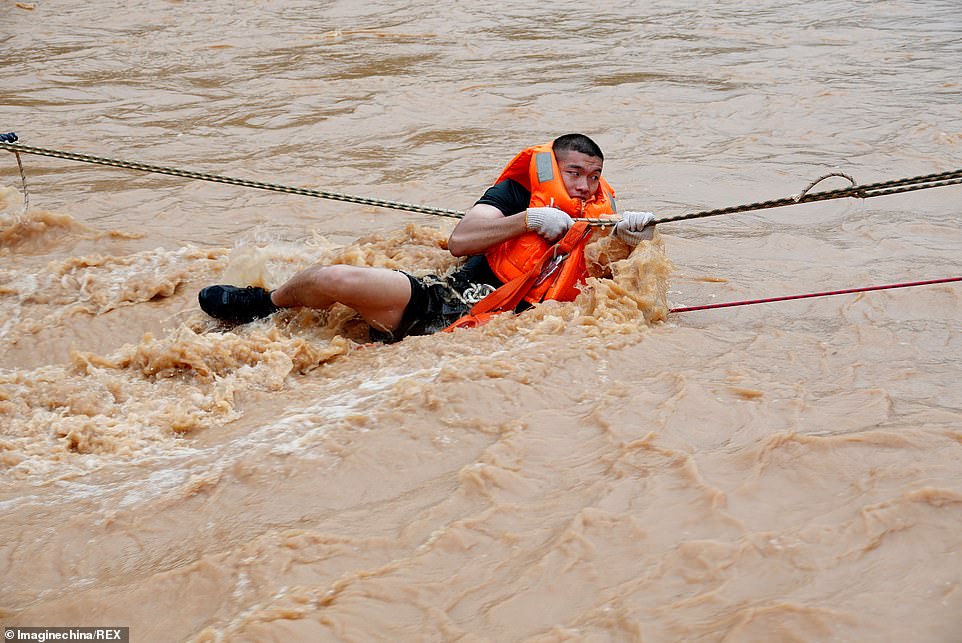 14789908-7142225-image-m-46_1560524675220 Chinese rescuers evacuate a local resident in floodwater caused by a heavy rainstorm in Heyuan city, Guangdong, yesterday