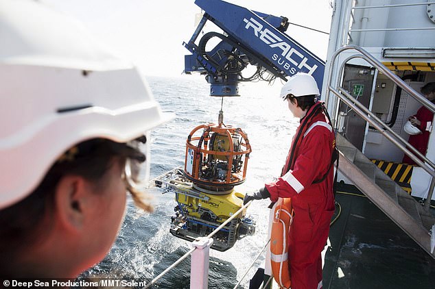 16350290-7273037-image-a-75_1563805572458 Incredible: Maritime experts look on as the ROV hangar is launched from Stril Explorer, helping to retrieve the shipwreck from the icy depths of the Baltic Sea