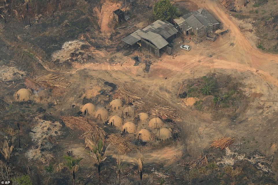 17650844-0-image-a-8_1566670972554 Brazil says military aircraft and 44,000 troops will be available to fight fires sweeping through parts of the Amazon region. Pictured:Â Charcoal-making furnaces and wooden planks are seen from the air, in the city of Jaci Parana, Rondonia state, one of the four that have asked for state help