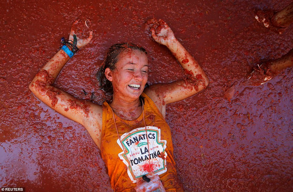 17792372-7403445-image-a-26_1567005331769 A delighted woman, dressed in a vest top with a mock Heinz Tomato Ketchup logo on it bearing the name of the festival, enjoyed her time in the tomatoes