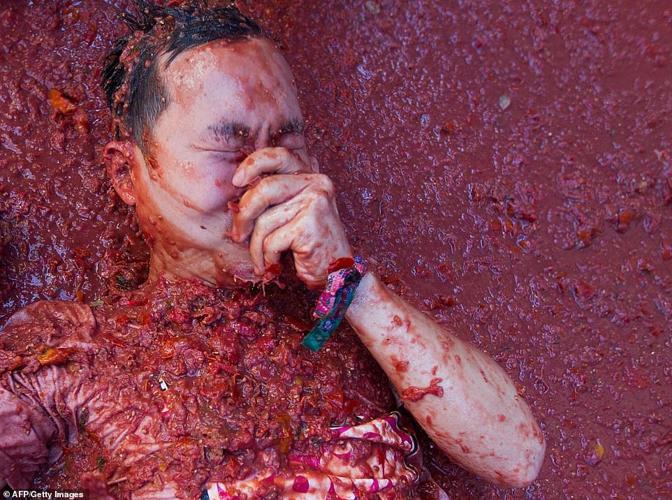 17792458-7403445-image-a-70_1567005506115 A reveller covered in tomato pulp takes part in the annual "Tomatina" festival in the eastern town of Bunol, on August 28