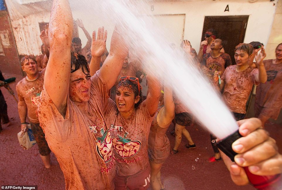 17792536-7403445-image-a-90_1567005611938 Afterwards, the streets are hosed down by organisers with people either hosing themselves, having a shower or diving into public lakes to get the pulp off