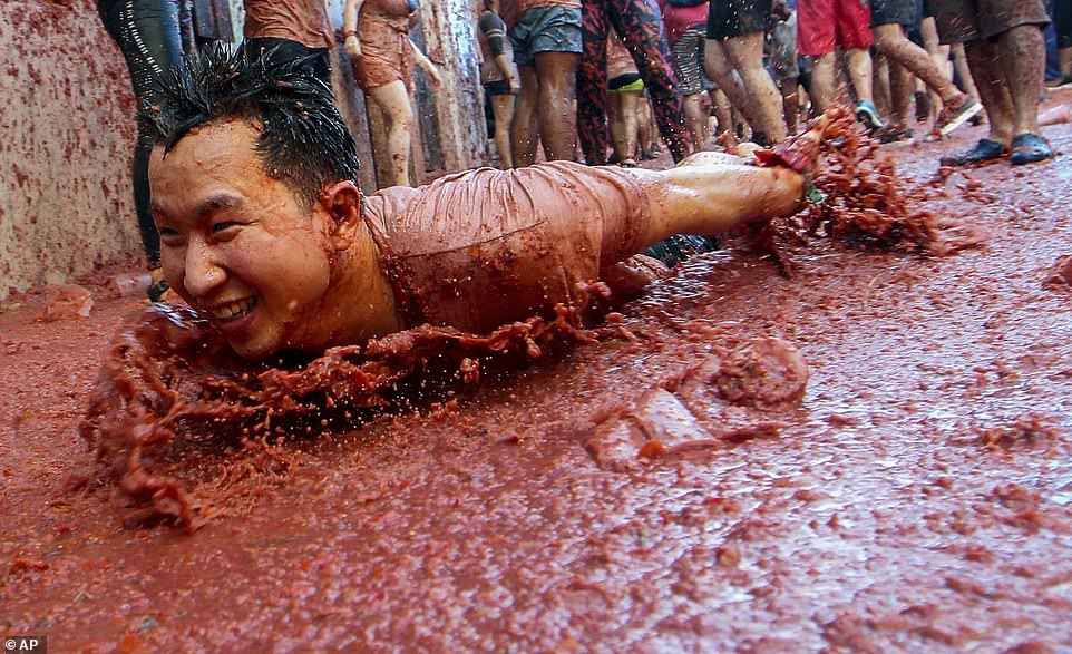 17792606-7403445-a_delighted_reveller_slides_along_the_ground-a-129_1567008493233 A delighted reveller slides along the ground during the festival, covering his front in a huge pile of tomato pulp at the event