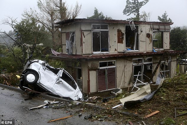 19627444-7565683-image-a-77_1570888472978 A damaged vehicle and house after a tornado caused by Typhoon Hagibis hit Ichihara