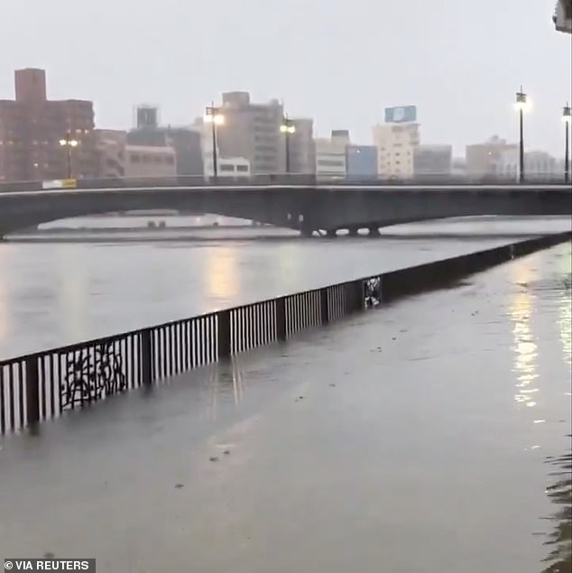 19627452-7565683-image-a-76_1570888468489 A view of an overflowing Sumida River on Saturday as Typhoon Hagibis approached Tokyo