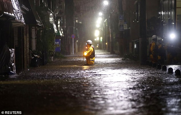 19628108-7565683-image-a-81_1570890238436 Firefighters patrol on a flooded road due to heavy rains caused by Typhoon Hagibis at Ota ward in Tokyo