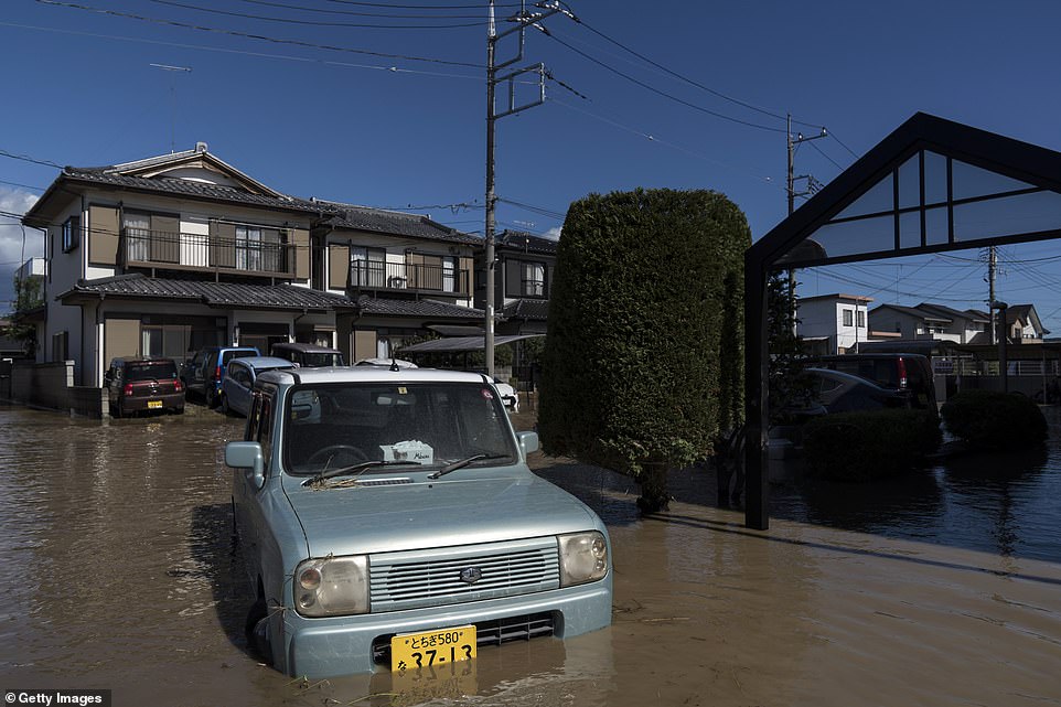 19647918-7567507-image-a-16_1570952478792 Houses and vehicles sit partially submerged in floodwater following the passage of Typhoon Hagibis on Sunday