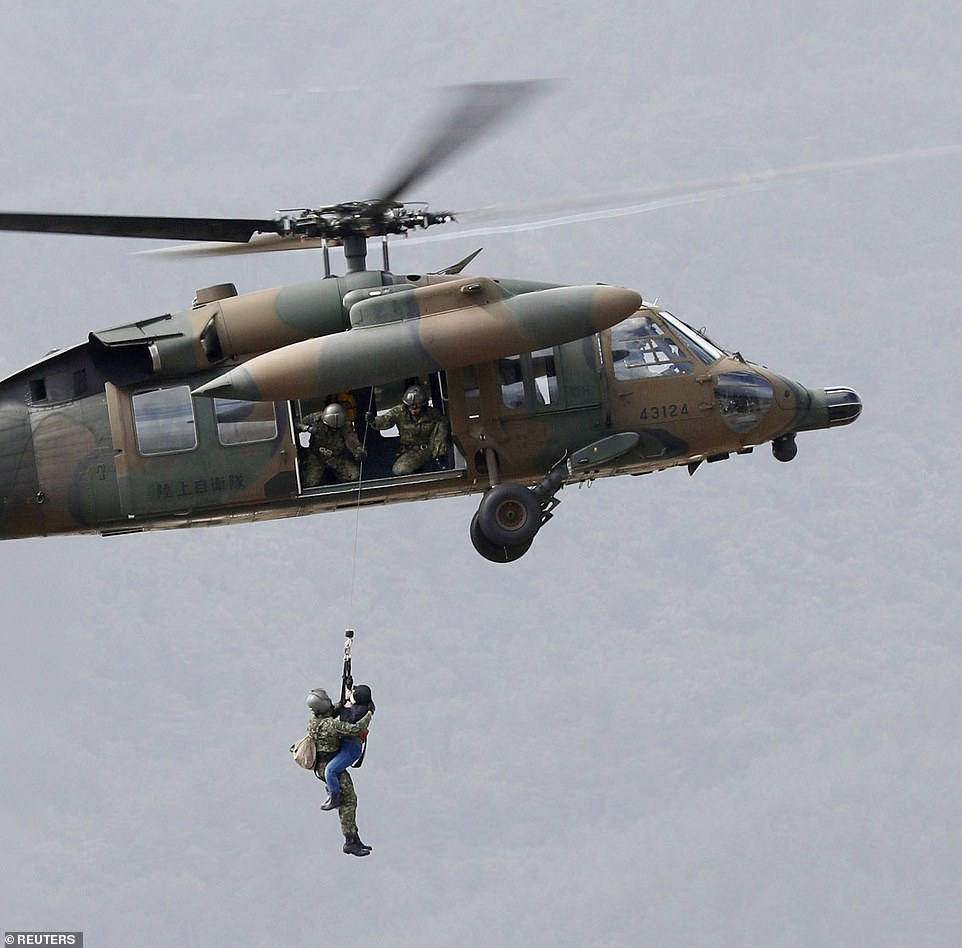 19647920-7567507-image-a-15_1570952450304 A local resident is rescued by a Japan Self-Defence Force helicopter from residential areas flooded by the Chikuma river in Nagano, central Japan on Sunday