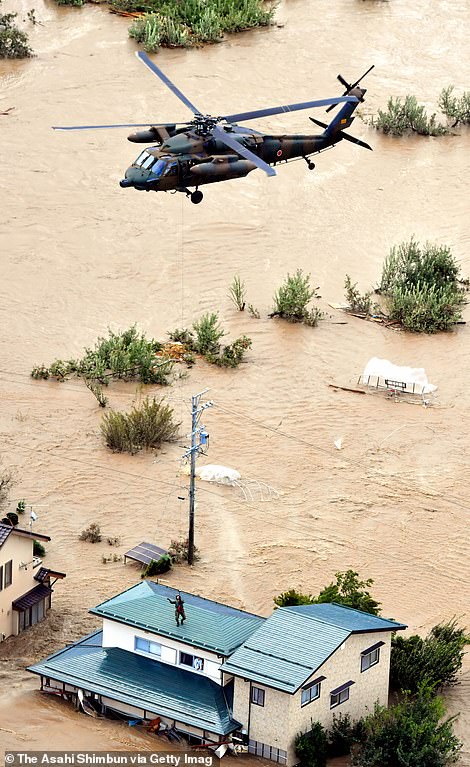 19647924-7567507-image-a-13_1570952321585 A local resident is rescued from a house submerged in flood water on Sunday
