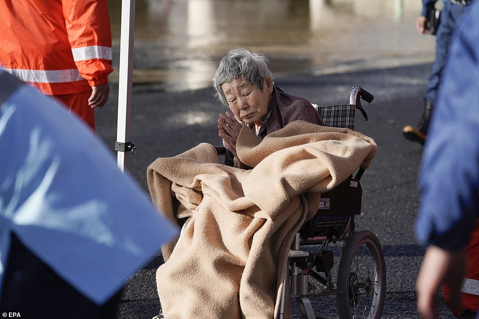 19651572-7567507-image-a-46_1570962097869 An elderly woman gestures as she was evacuated along with others from a nursing home flooded by Typhoon Hagibis, before being moved to another facility in Nagano on Sunday