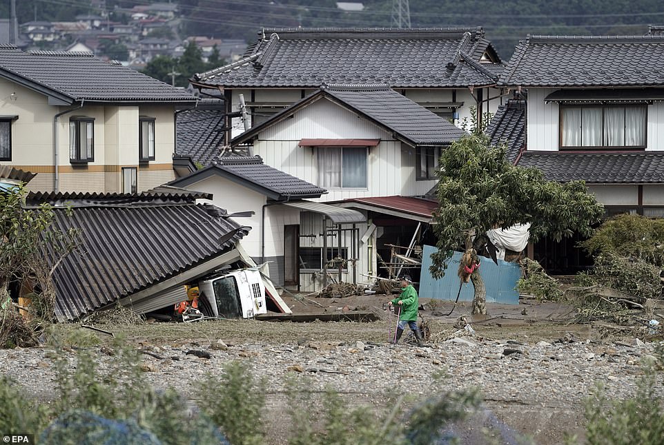 19679926-7570251-image-a-18_1571037619220 A resident walking towarda his house in the Hoyasu area which is flooded and devastated by Typhoon Hagibis, in Nagano